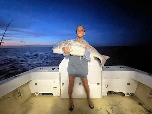 Lady Gecko angler hugs massive red drum she caught.